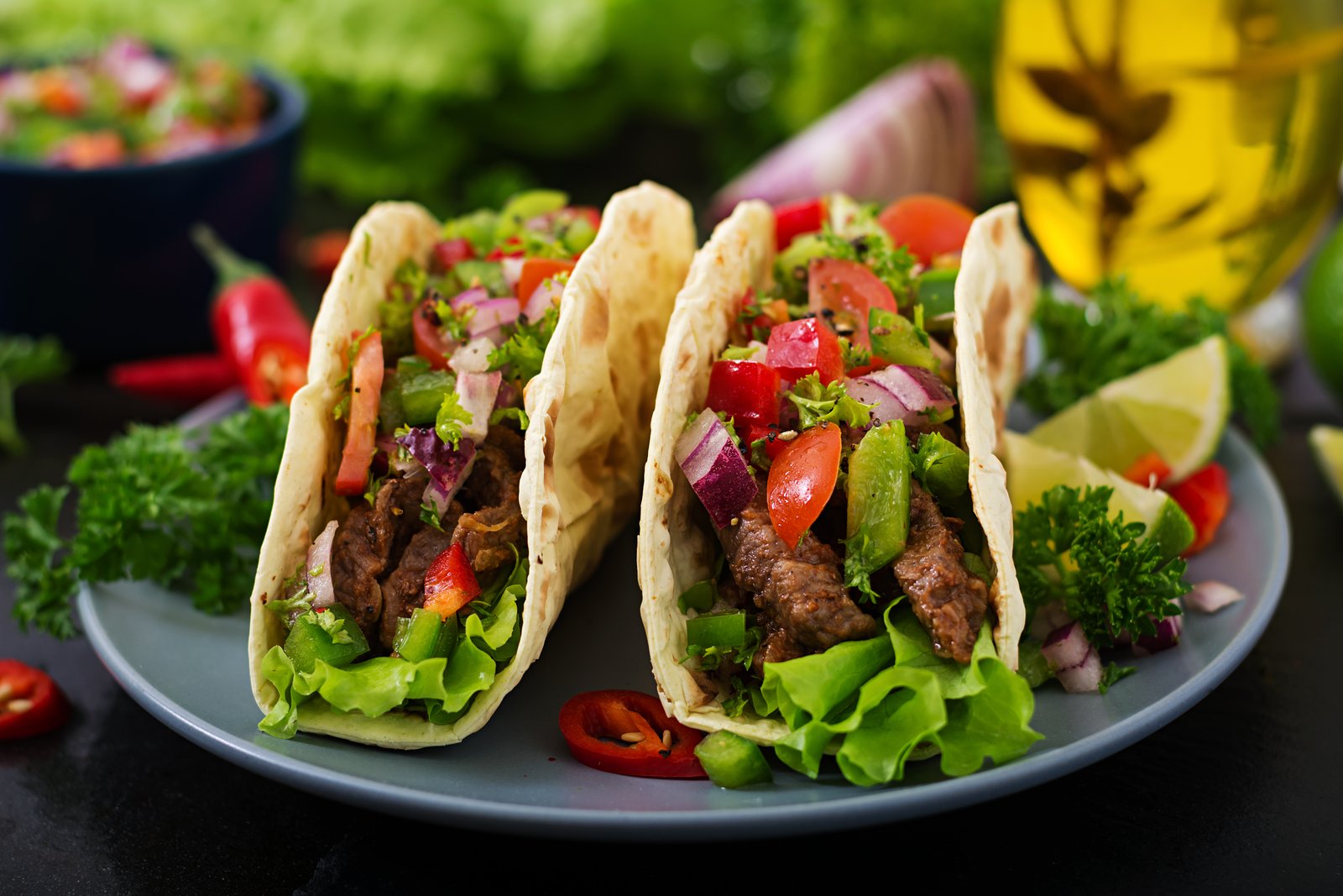 Beef tacos with fresh tomato salsa, peppers and lime